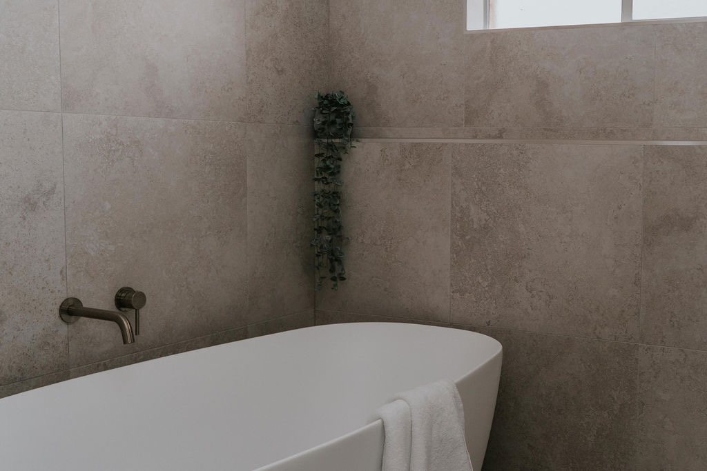 Freestanding bath with a brushed bronze bath filler in a Gold Coast bathroom renovation