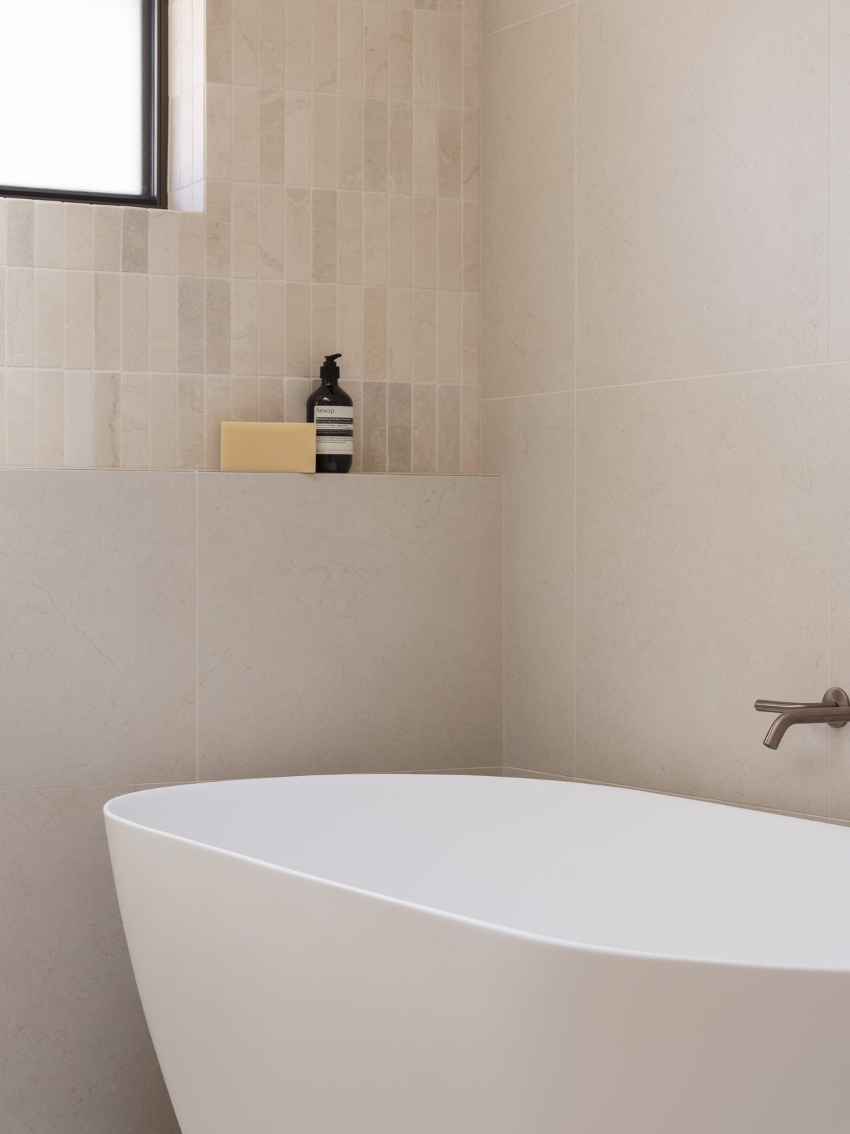 Freestanding bath with a tiled shelf niche and window in a Gold Coast bathroom renovation