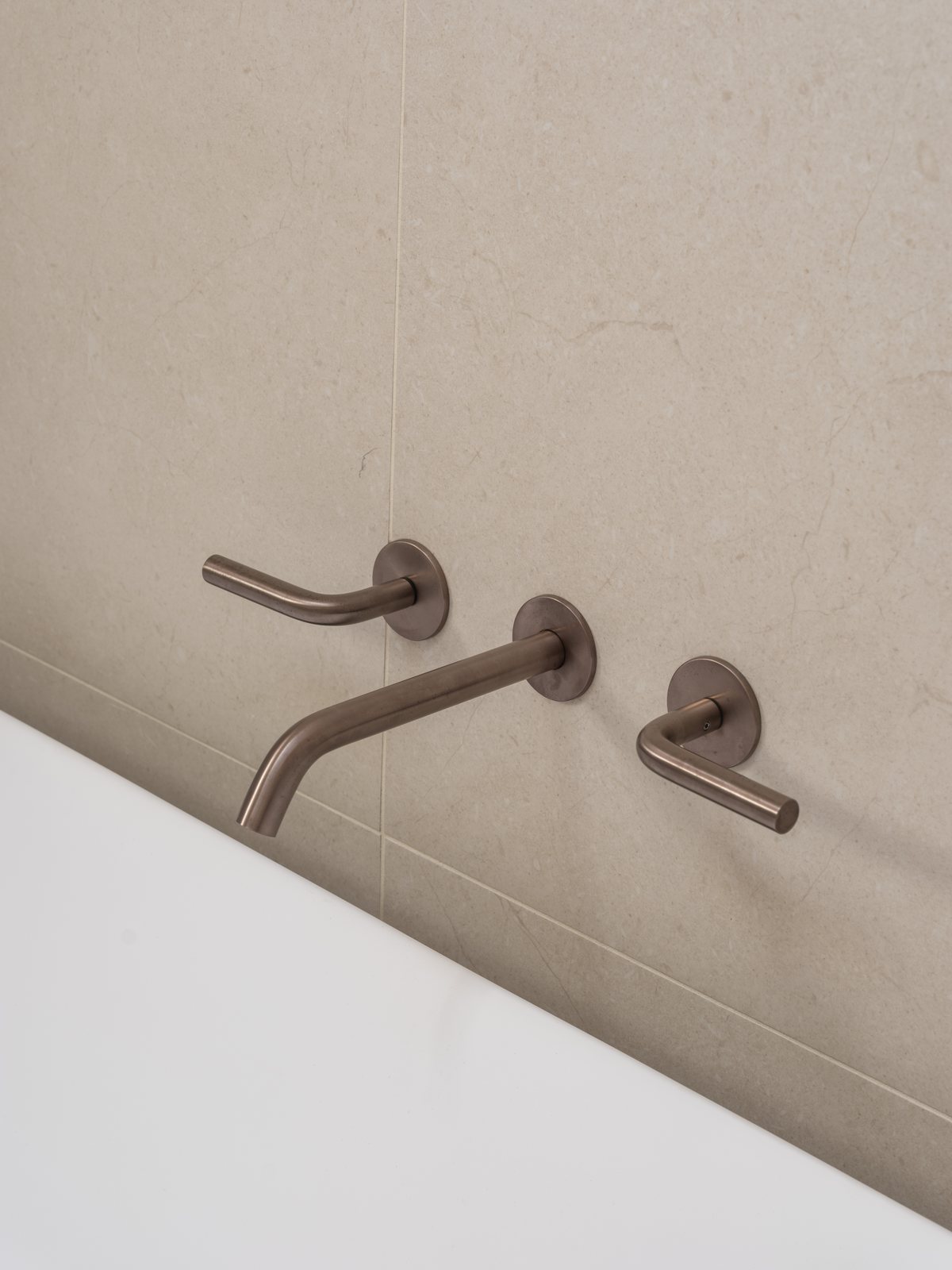 Brushed bronze wall mixers over a stone vanity in a Gold Coast bathroom renovation