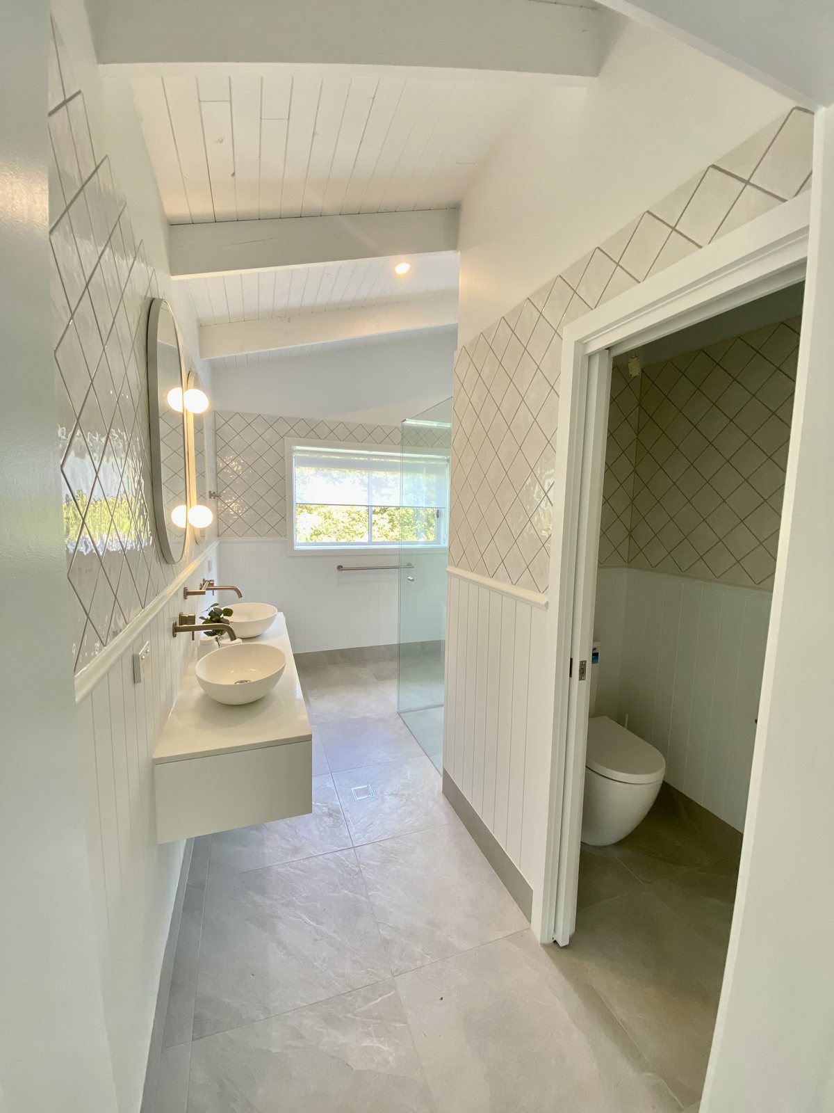 Bright Gold Coast bathroom renovation with a floating double vanity, twin basins and a separate toilet