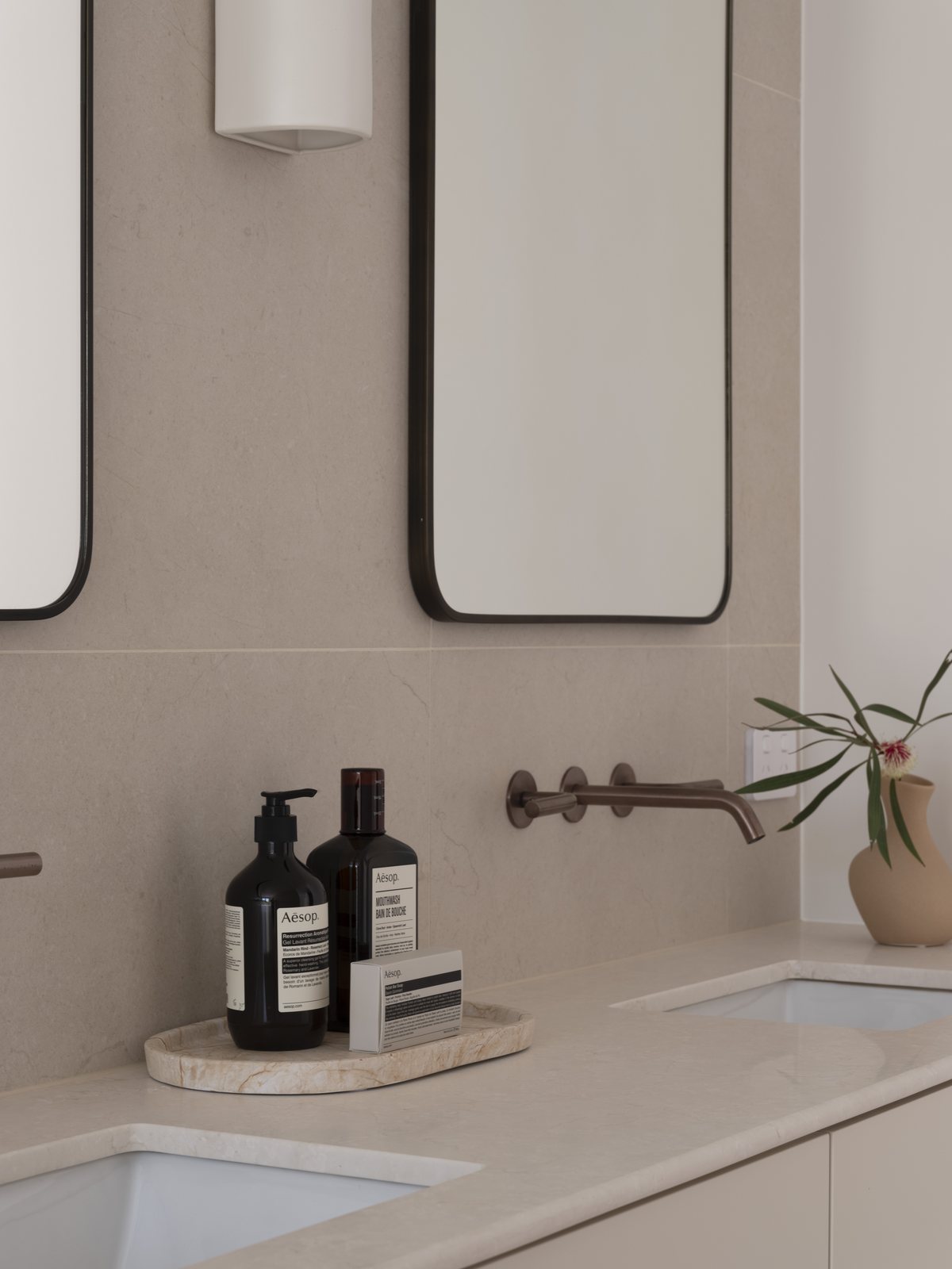 Double vanity with twin undermount basins, twin mirrors and brushed bronze wall mixers in a Gold Coast bathroom renovation