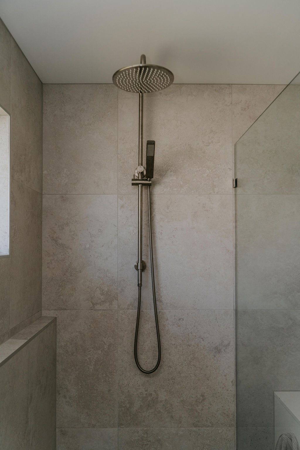 Tiled shower with a brushed bronze rail shower in a Gold Coast bathroom renovation