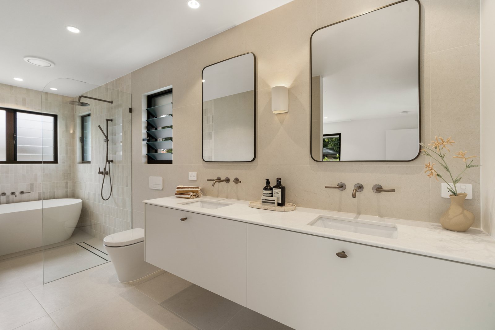 Renovated Gold Coast bathroom with twin vanities, a walk-in shower and a freestanding bath