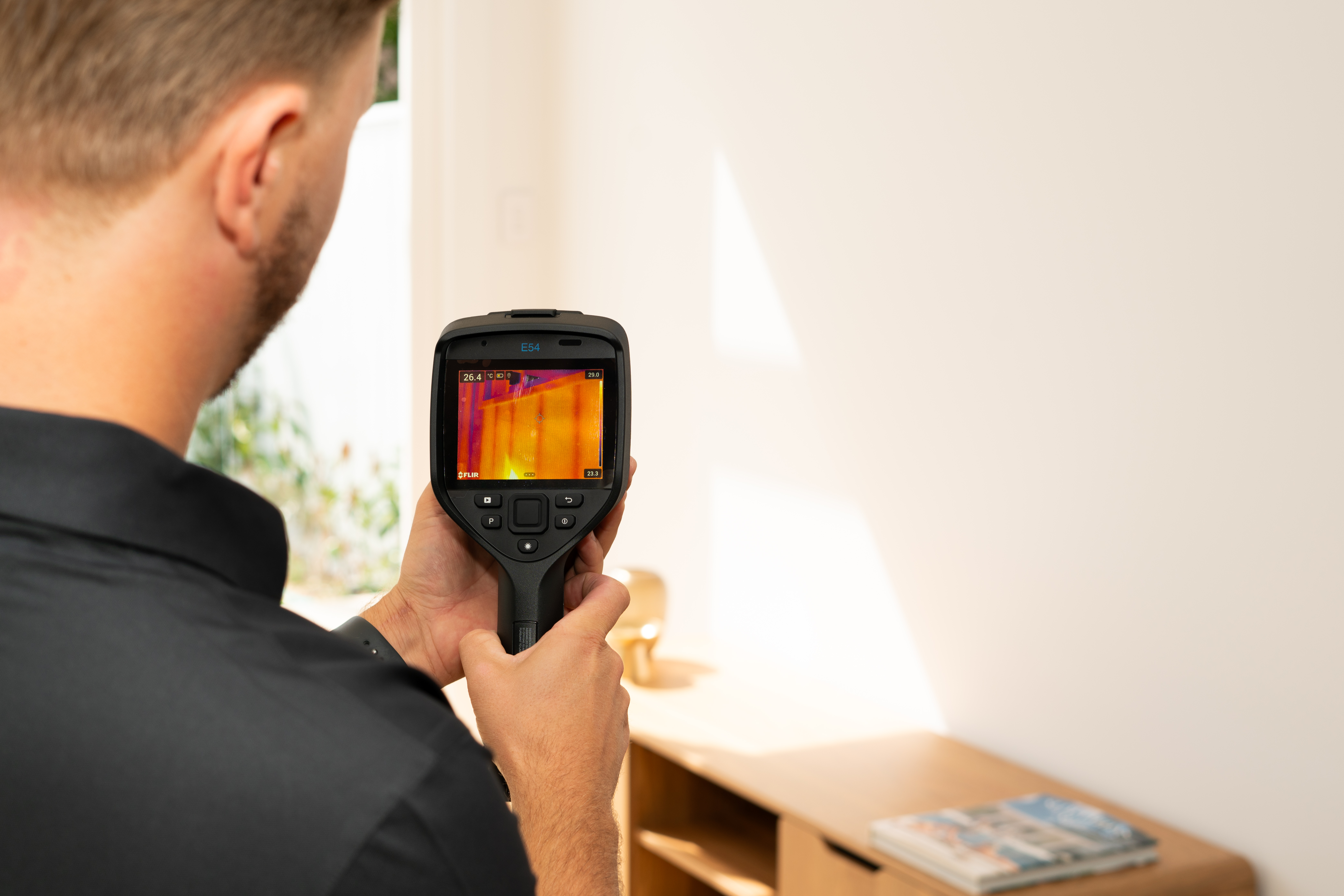 A QBCC licensed building inspector using a thermal imaging camera during a Gold Coast property inspection